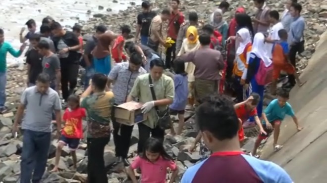 Petugas Polsek Tanjungpinang saat mengevakuasi jenazah bayi dalam kardus untuk proses penyelidikan.     