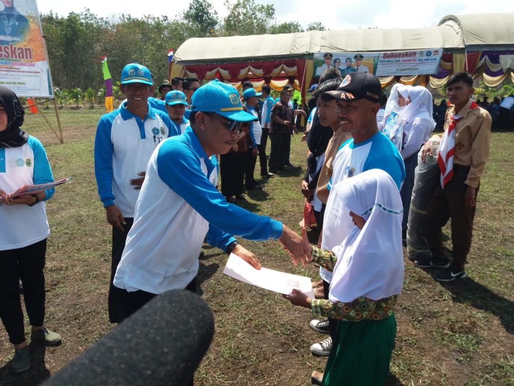 Kadis Dukcapil Aruji, SH Saat Menyerahkan Dokumen Kependudukan Bagi Warga Berbak