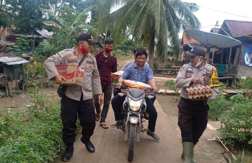 Kapolsek Nipah Panjang, IPDA. Ramadhan Agustiansyah, SH (kiri) saat memberikan bantuan kepada warga korban musibah kebakaran