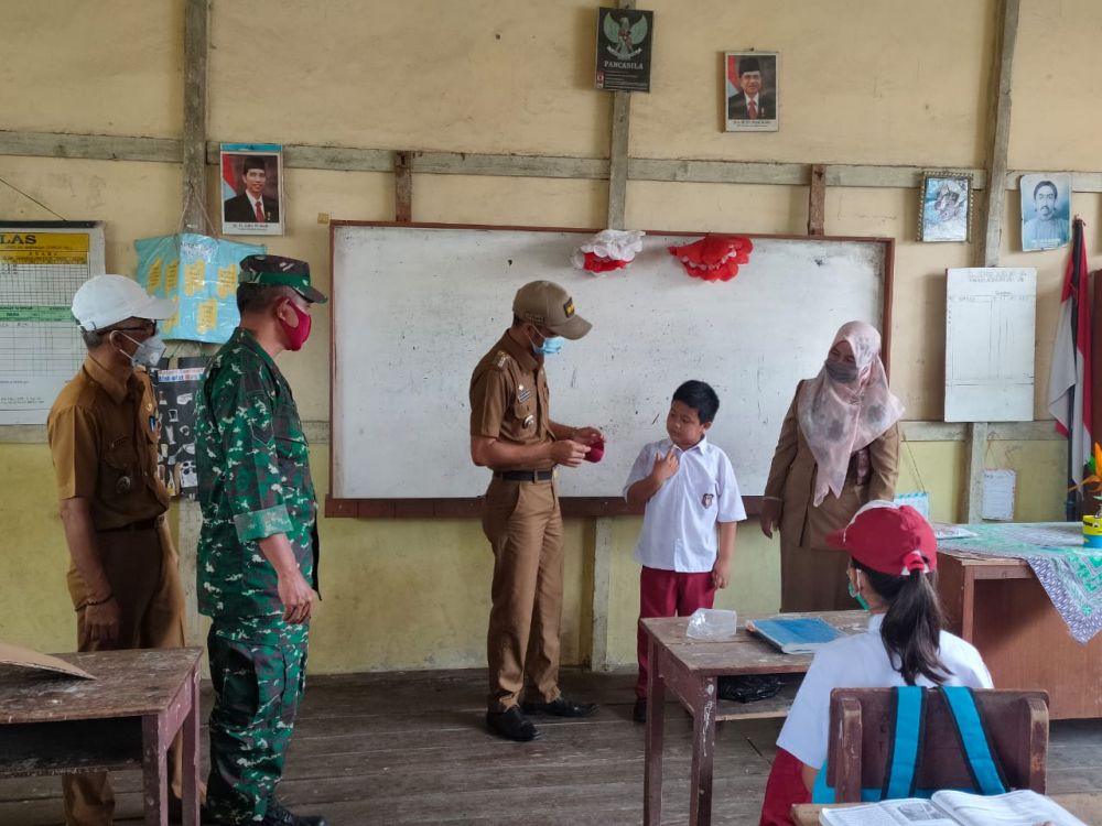 Camat Kuala Jambi, Taufiq Kurniawan saat membagikan Masker ke pelajar