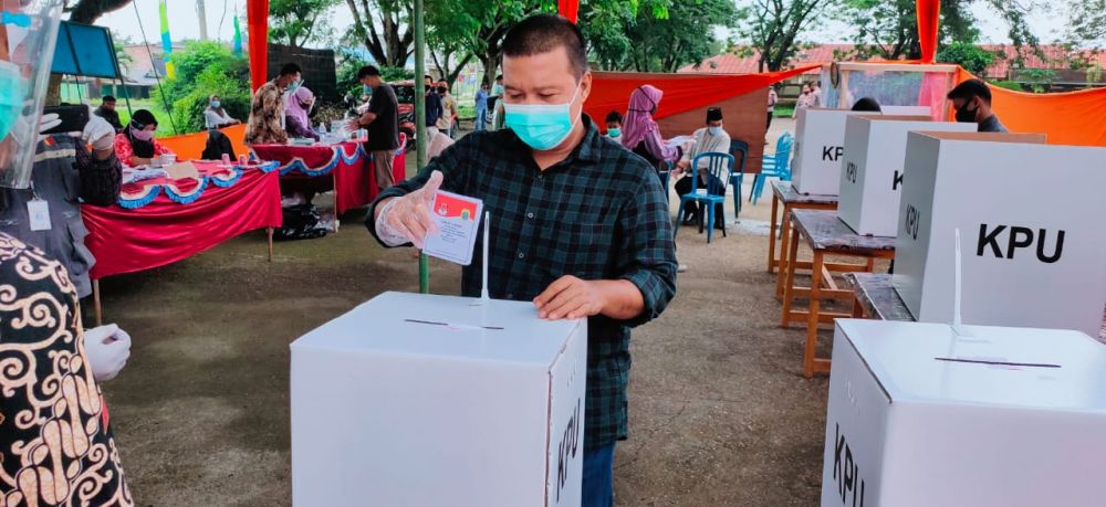 Bupati Tanjabtim, Romi Hariyanto saat mencoblos menerapkan protokol kesehatan