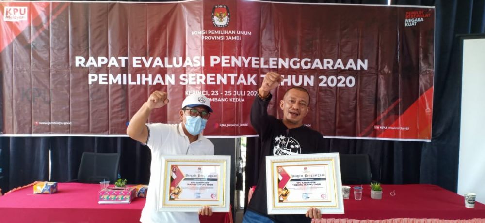 Penyerahan penghargaan oleh anggota KPU Provinsi kepada penerima penghargaan