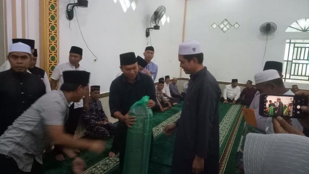 Nugraha Setiawan Saat Menyerahkan Bantuan Paket Sejadah kepada Pengurus Masjid