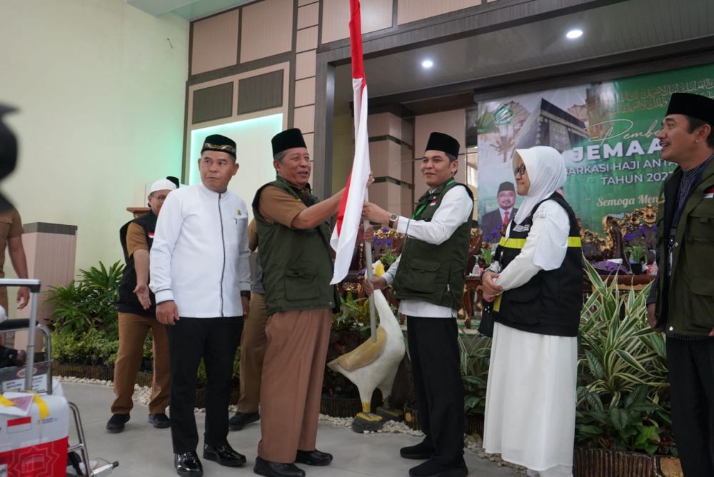 Wagub Sani Menyerahkan Sangsaka Merah Putih Tanda pelepasan CJH 