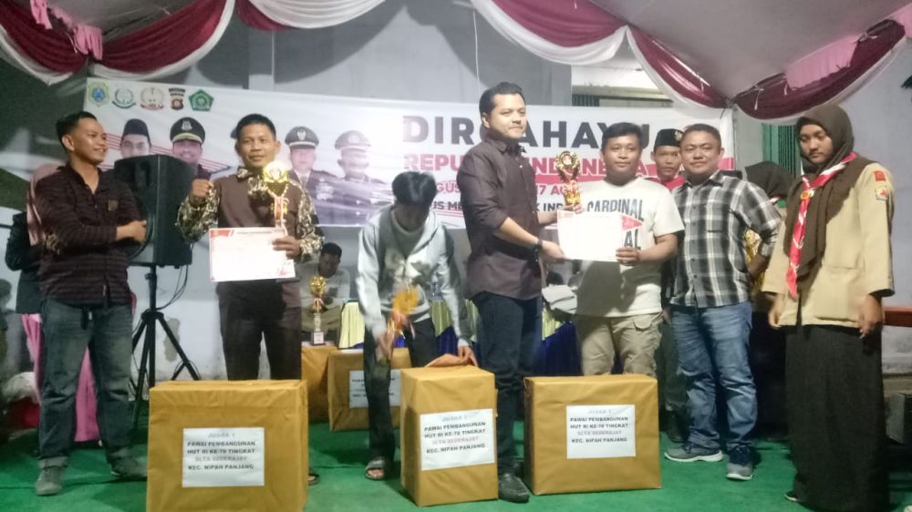 Camat Nipah Panjang Ulfi saat menyerahkan Hadiah kepada Pemenang Lomba Pada HUT RI 