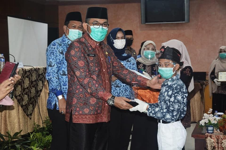 Sudirman saat menyerahkan hadiah Lomba Perpustakaan dan Kepustakawanan Tingkat Provinsi Jambi Tahun 2020